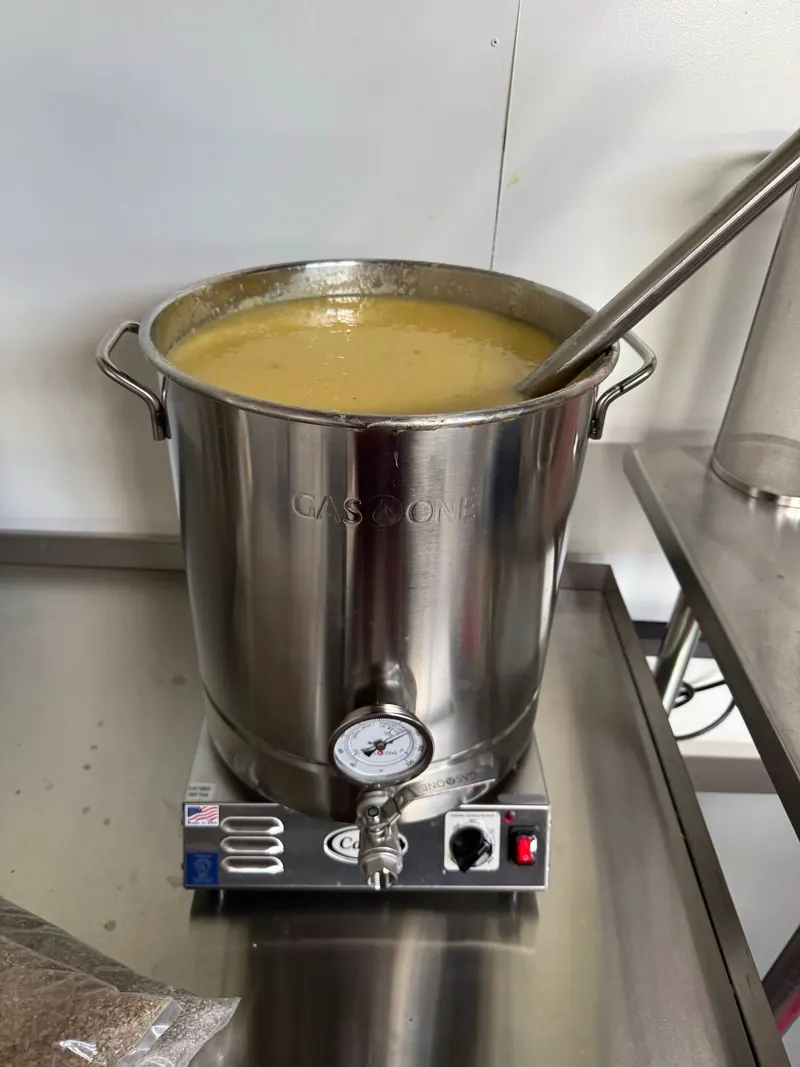 Mash heating in a stainless kettle with a thermometer