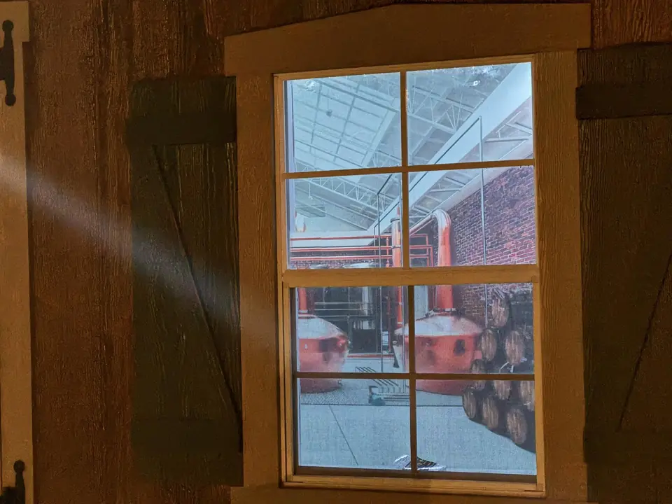 A copper still glimpsed through the panes of an old wooden window